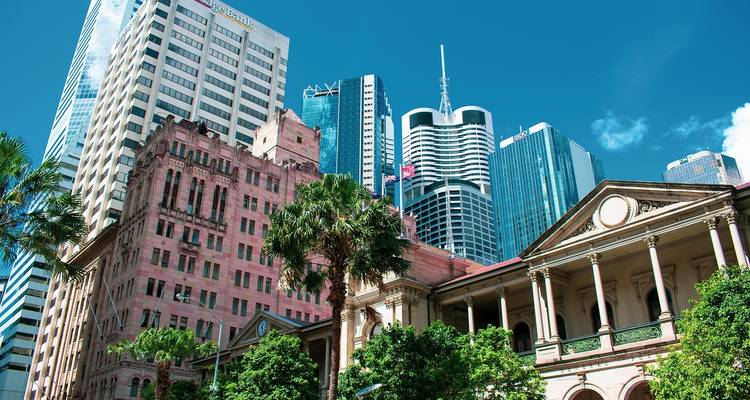 Hoge gebouwen en palmbomen in een levendige stad.