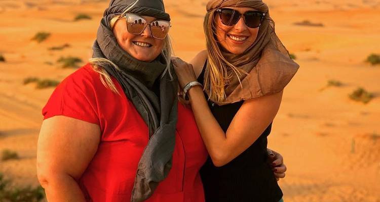 Deux femmes vêtues de foulards debout dans un désert.