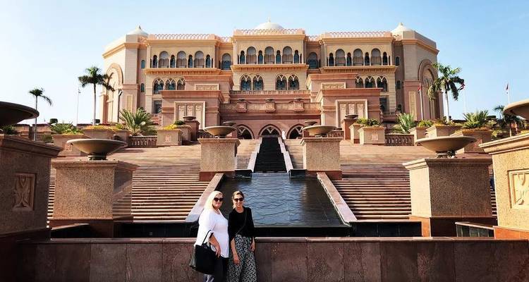 Deux femmes devant un grand bâtiment luxueux.