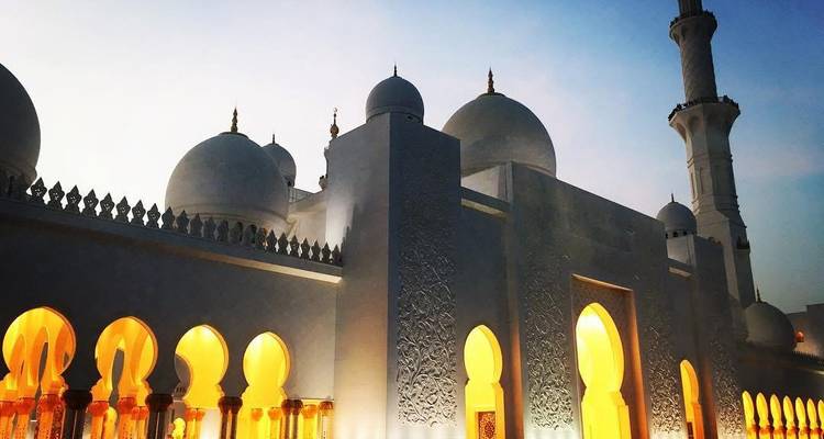 Extérieur d'une mosquée magnifiquement éclairée au crépuscule.