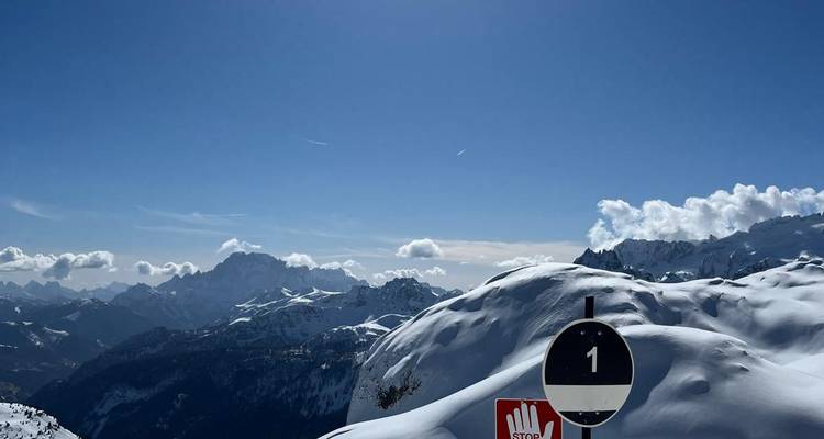 Paysage enneigé avec un panneau stop sur un poteau.
