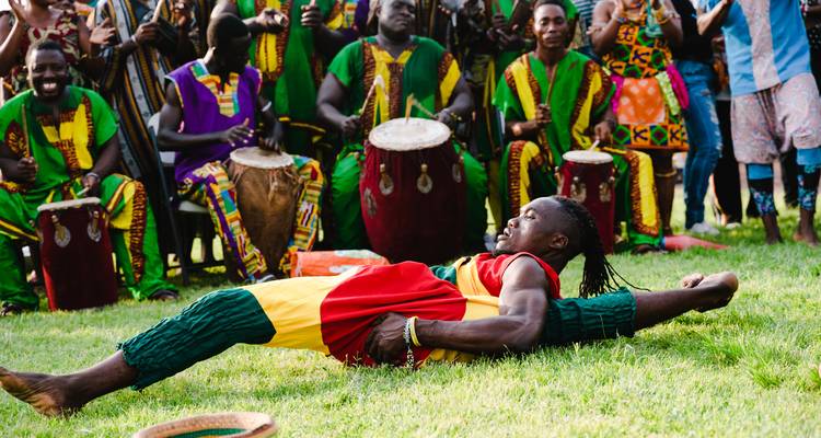 Groupe de personnes en tenue traditionnelle exécutant une danse culturelle.