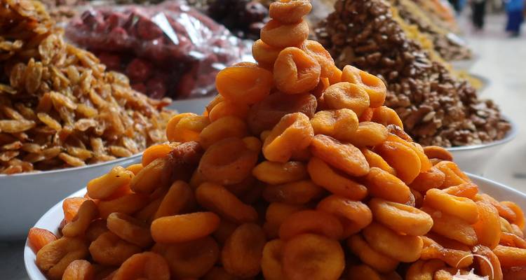 Tas d'abricots secs avec d'autres fruits en arrière-plan.