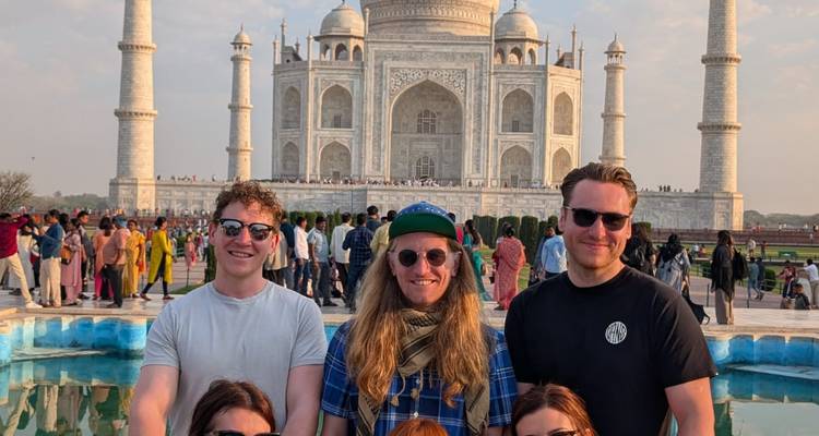 Reizigers poseren voor de reflectievijver met de Taj Mahal die erachter oprijst.