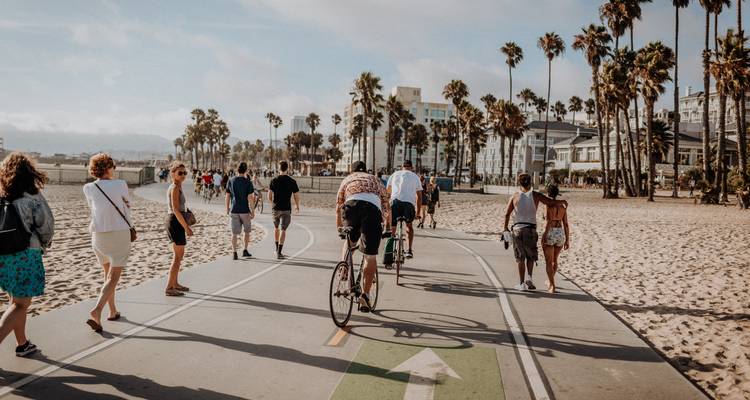Des gens qui marchent et font du vélo le long d'un sentier en bord de mer.
