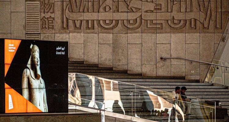 Interior del museo con personas cerca de un letrero de Gran Salón y escalera.