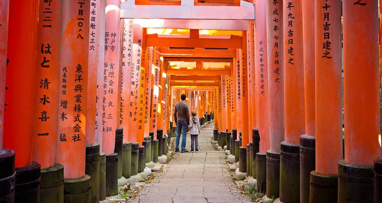 Portiques torii avec des personnes qui les traversent au sanctuaire Fushimi Inari.