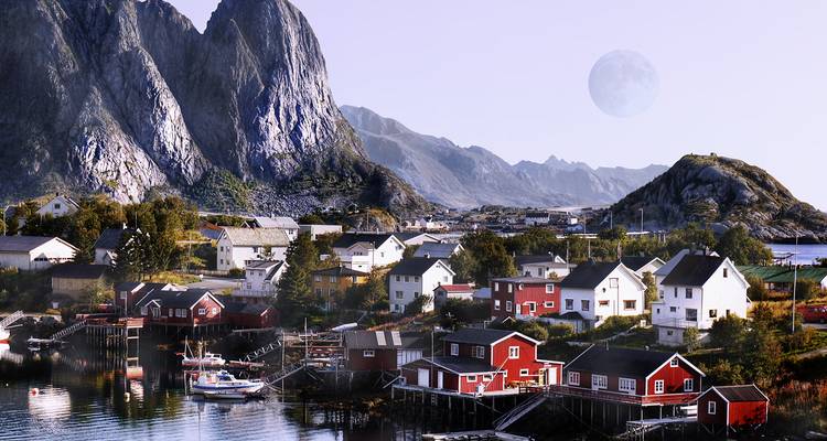 Ville côtière avec des maisons en bois dominée par de grandes montagnes rocheuses.