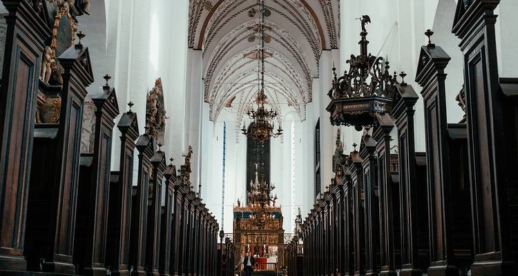 Intérieur d'une église avec des lustres décoratifs et un autel.