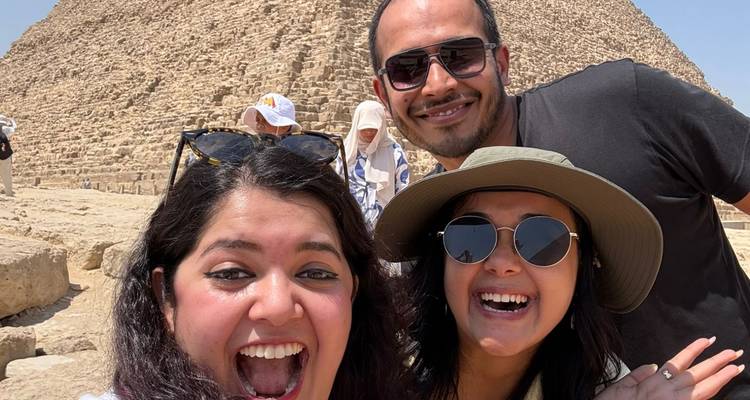 Des touristes prenant un selfie devant les pyramides de Gizeh.