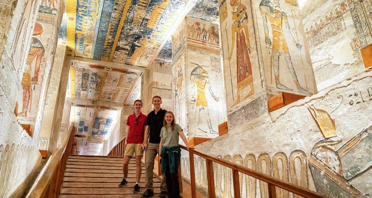 Une famille posant sur un escalier décoré au sein d'un tombeau pharaonique aux couleurs éclatantes dans la Vallée des Rois.