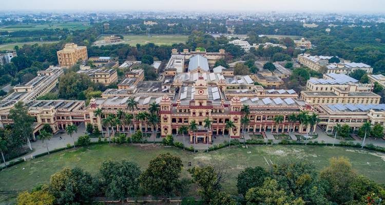 Vue aérienne d'un complexe de bâtiments historiques entouré de verdure.