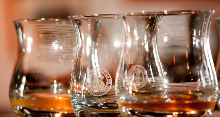 Verres à whisky Glencairn avec liquide ambré sur une table.