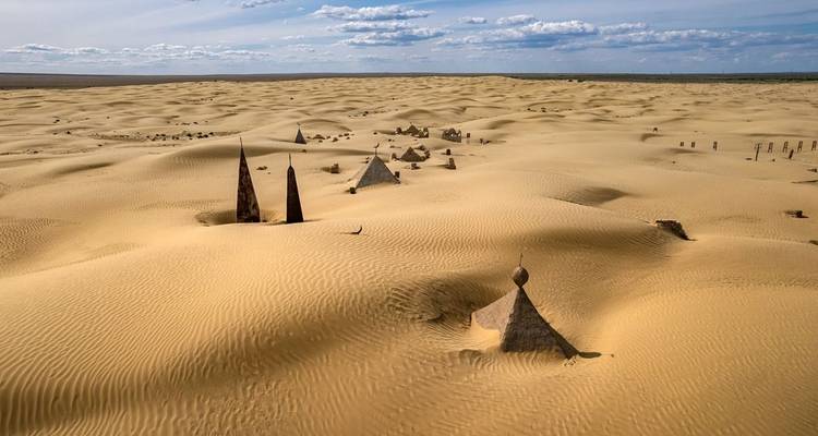 Desierto arenoso con formaciones rocosas dispersas.