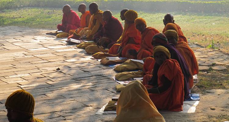 Monks sitting in a row during a spiritual gathering.