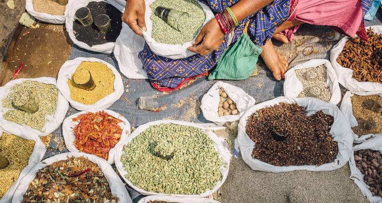 Varias especias en sacos en un mercado al aire libre bullicioso.