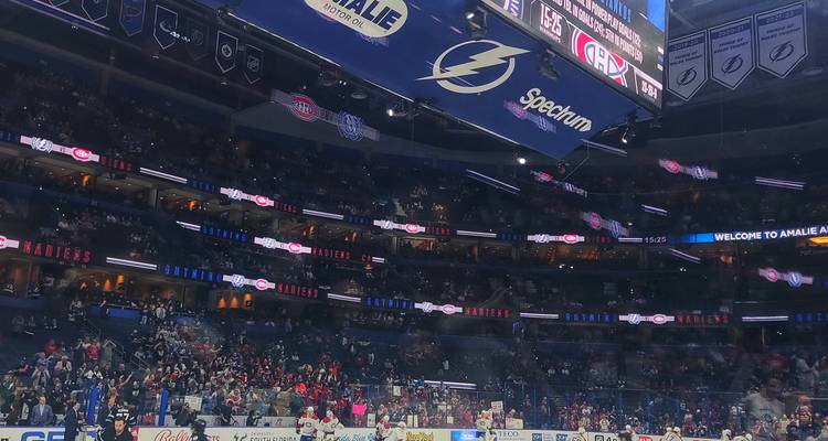 Stade sportif intérieur accueillant un match de hockey.