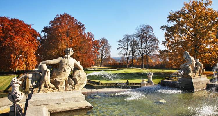 Autumn view of a garden with statues and fountains.