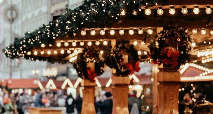 Festive market stall with lights and wreaths.