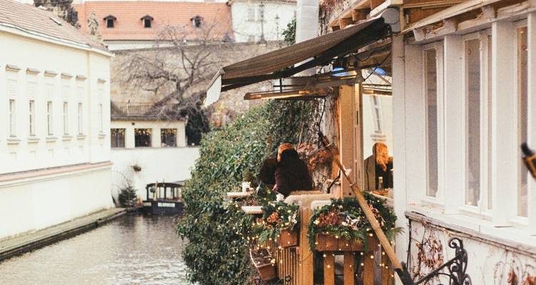 Riverside café with festive decorations and people.