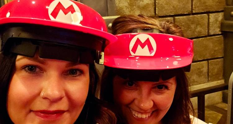 Deux femmes portant des chapeaux de Mario, souriant à la caméra.