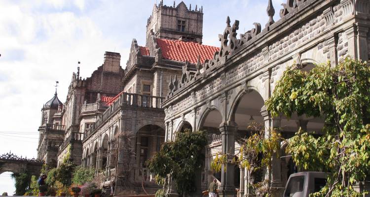 Un gran edificio histórico con arquitectura ornamentada y tejado rojo.