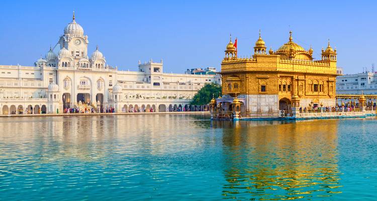 El Templo Dorado brillaba bajo la luz solar radiante rodeado por el sagrado estanque Amrit Sarovar