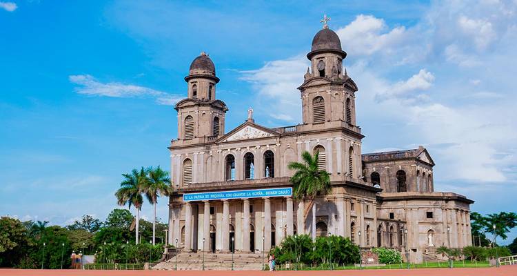 Een oude kathedraal met hoge spitsen onder een blauwe hemel.