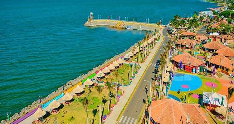 Kleurrijk uitzicht op de waterfront met gebouwen en een straat naast een meer of zee.