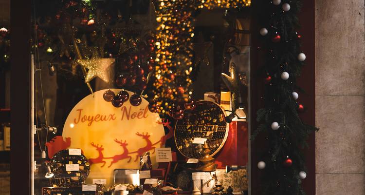 Vitrine de magasin de Noël avec des décorations festives.