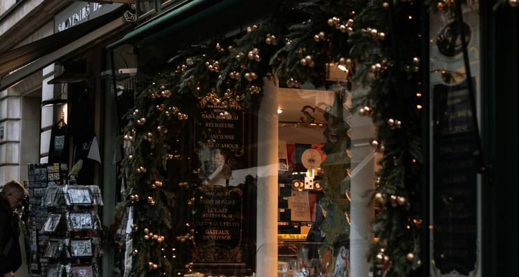 Décorations de Noël sur une devanture de magasin avec éclairage festif.