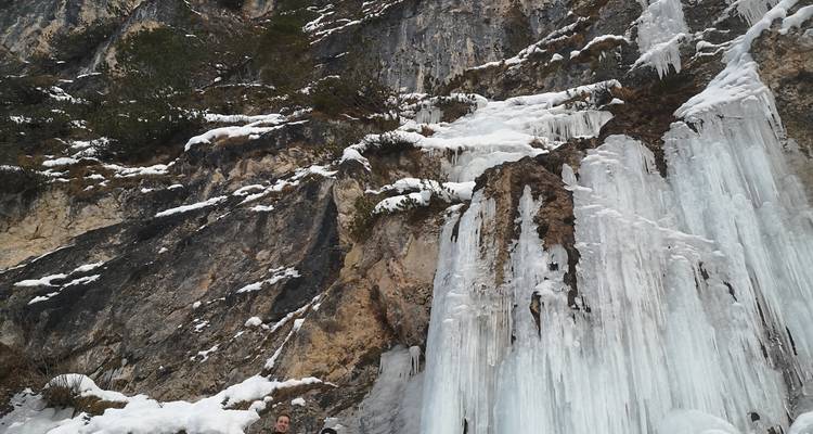 Cascade gelée dégringolant le long d'une paroi rocheuse.
