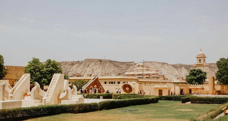 Los instrumentos de piedra del observatorio Jantar Mantar se encuentran entre los céspedes con colinas de fondo.