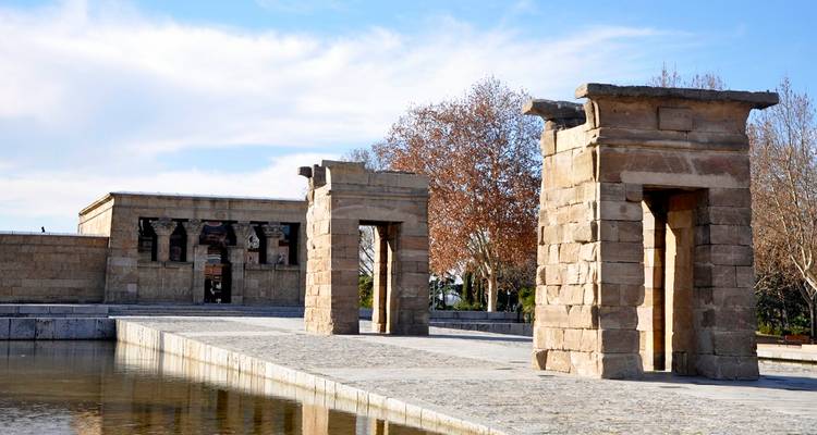 Ancient Egyptian-style temple with a reflecting pool and clear sky.