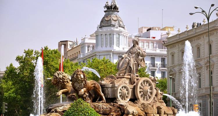 Majestic fountain with statues and historical buildings.