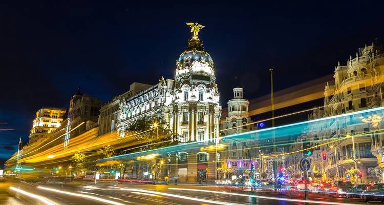 Night scene with city lights and light trails from vehicles.