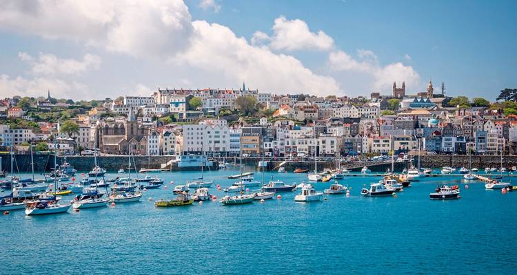 Harbor with boats and colorful buildings on coastline.