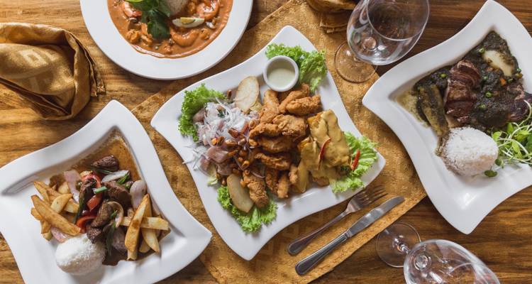 An assortment of traditional Peruvian dishes plated on a table.