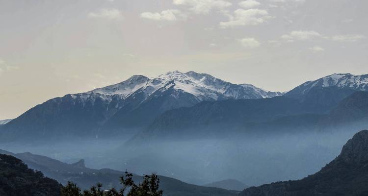 Berglandschap met besneeuwde toppen en mist.
