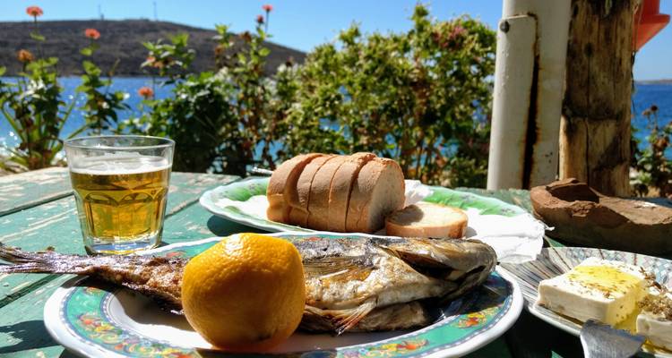 A table with food, including fish, bread, and beer.