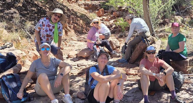Gruppe von Wanderern, die eine Pause auf einem felsigen Wanderweg einlegt.