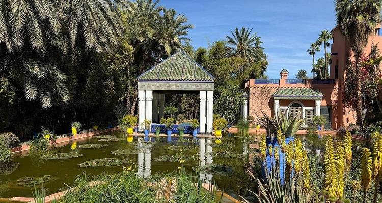 Jardin avec un bassin et un pavillon entourés d'une végétation luxuriante.