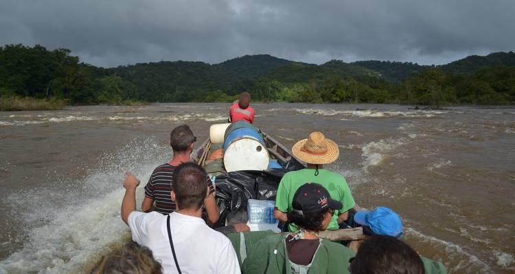 Group of people on a boat navigating a river.