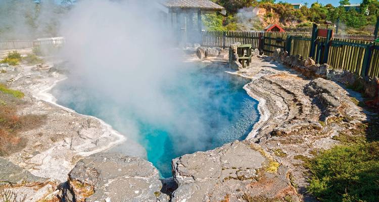 Sources chaudes avec de la vapeur qui s'élève, entourées de formations rocheuses.