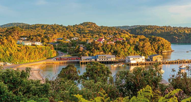 Village côtier entouré d'une végétation luxuriante et d'une baie calme.