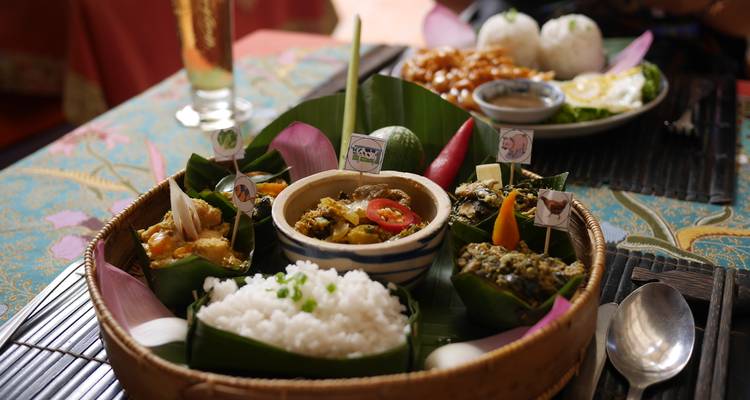 Close-up van traditionele Cambodjaanse gerechten kunstzinnig gepresenteerd in bananenbladen met rijst en curry.