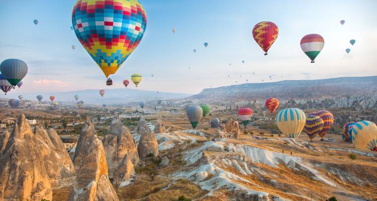 Heteluchtballonnen die zweven boven rotsformaties in Cappadocië, Turkije.