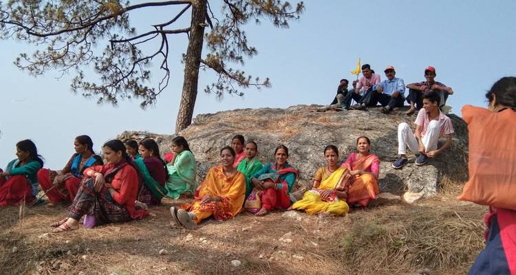 Groupe de personnes assises à l'extérieur par une journée ensoleillée.