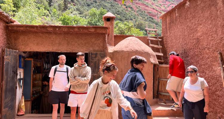 Groupe de personnes marchant dans un village marocain traditionnel.