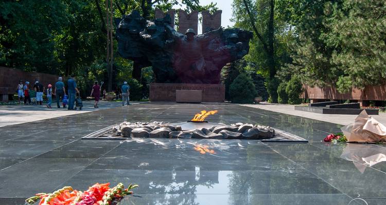 Flamme éternelle avec un monument dans un parc commémoratif.